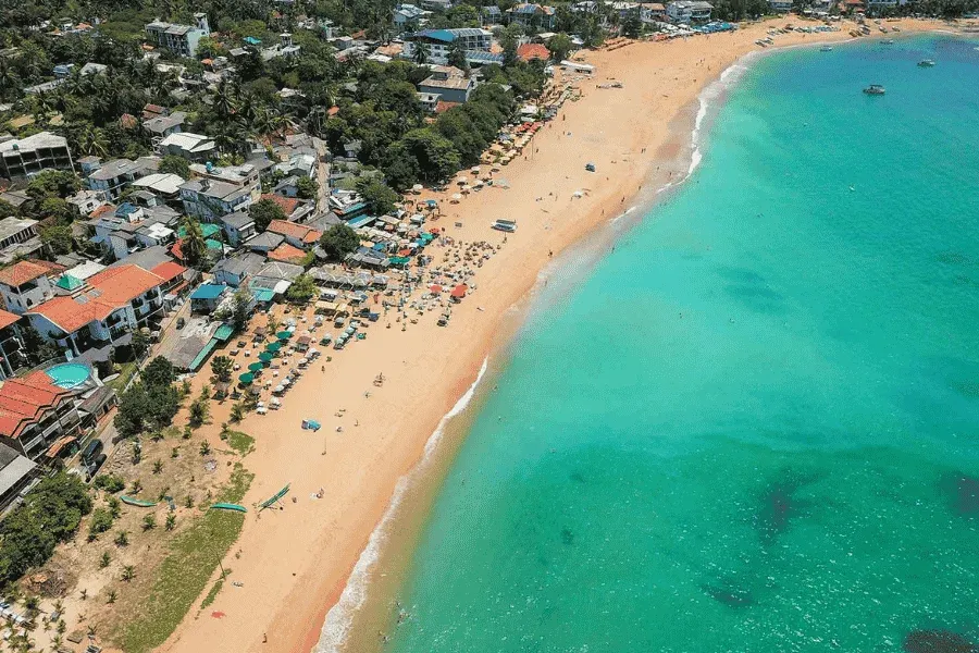 Unawatuna bay golden beach jungle-covered hills Sri Lanka