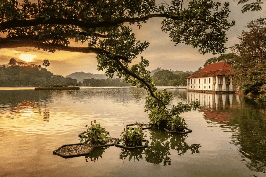Kandy Lake at sunset with the Temple of the Tooth and surrounding hills reflected in the water