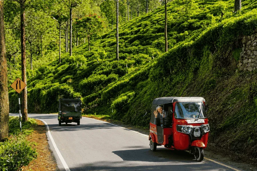 Tuk tuk driving through Sri Lanka's central highlands toward Kandy